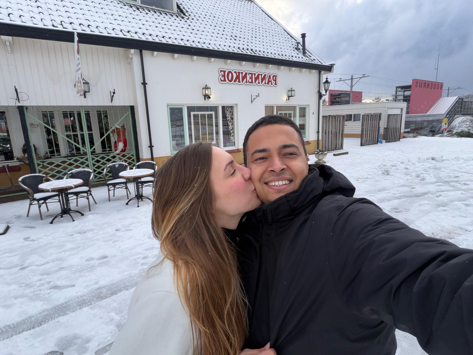 A kiss in the snow outside a pancake house